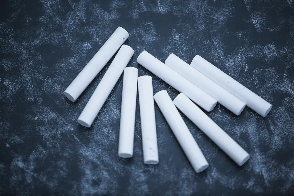 White PAK chalk sticks on a blackboard